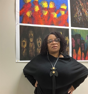 Black woman librarian standing in front of colorful artwork